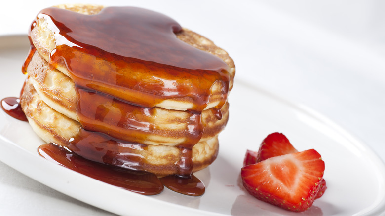 Stack of pancakes covered in maple syrup