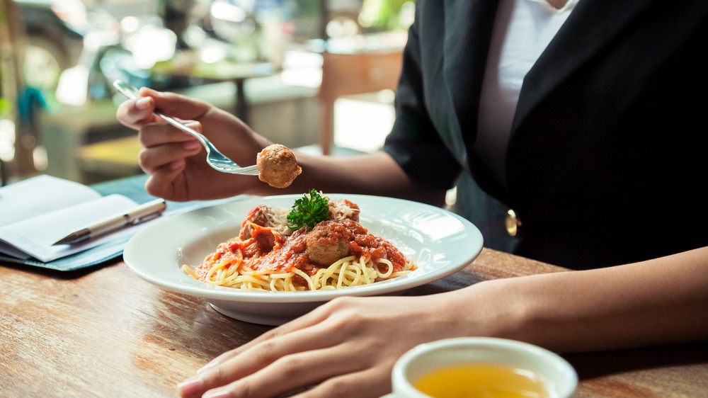 Woman eating spaghetti and meatballs