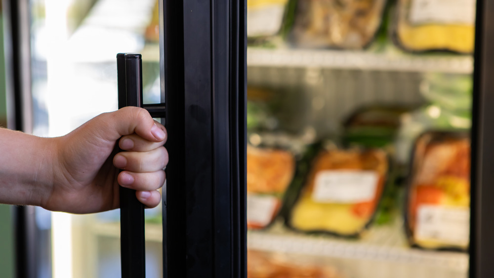 Hand opening supermarket fridge