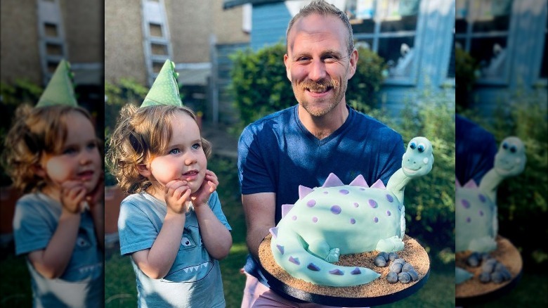 Steven Carter-Bailey presenting dinosaur-shaped cake