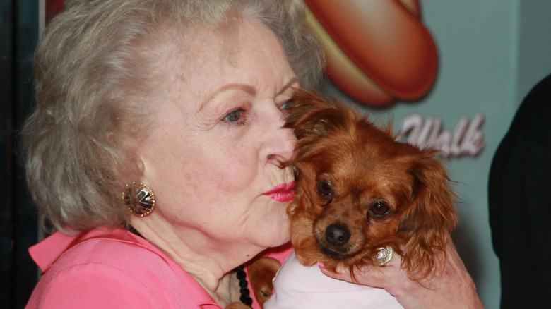 Betty White hugging a dog