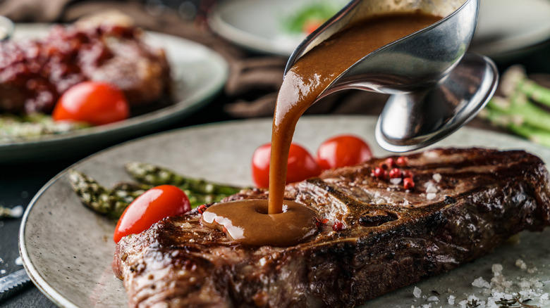 Sauce being poured over a steak