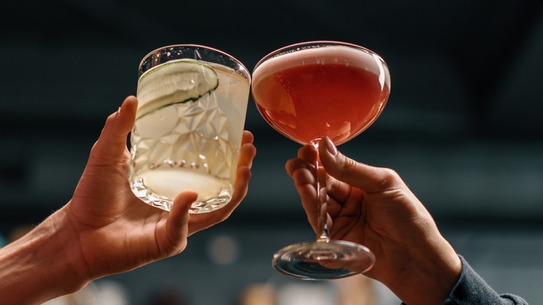 Two people toasting cocktails