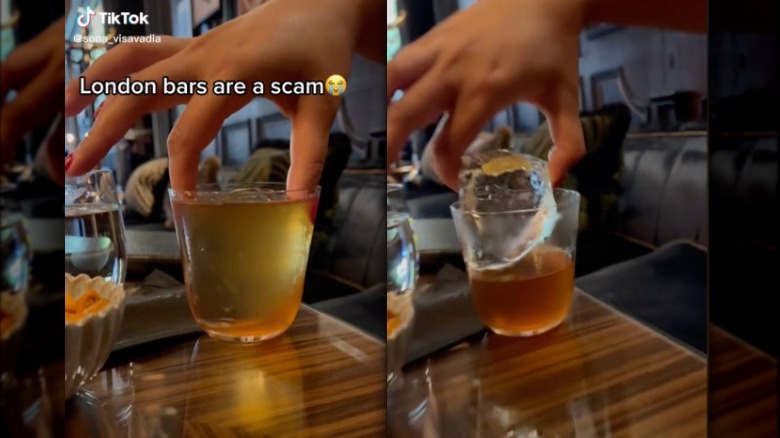 person lifting large ice cube out of cocktail