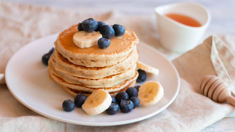 Pancakes with bananas, blueberries, and honey