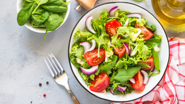 Mixed greens salad next to fork