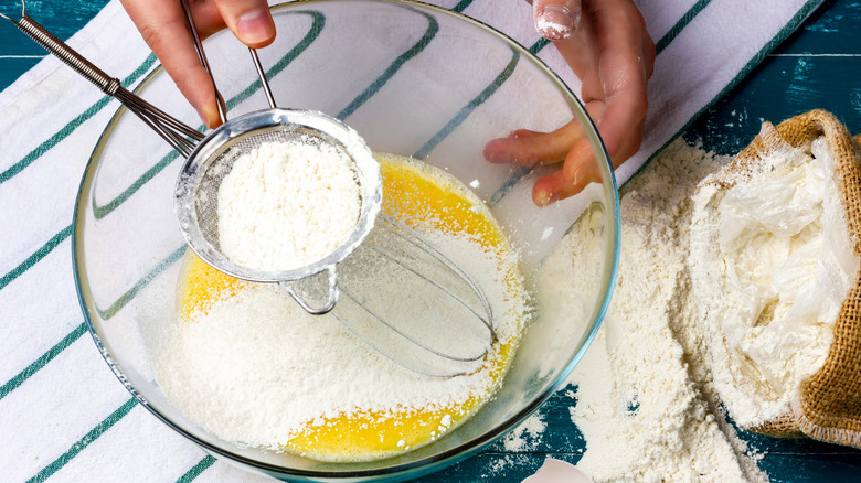 Sifting flour over egg mixture