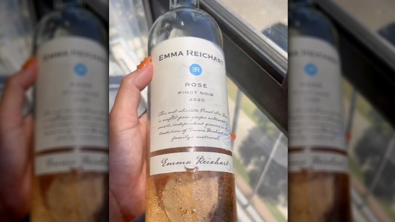 Holding Emma Reichart Rosé bottle