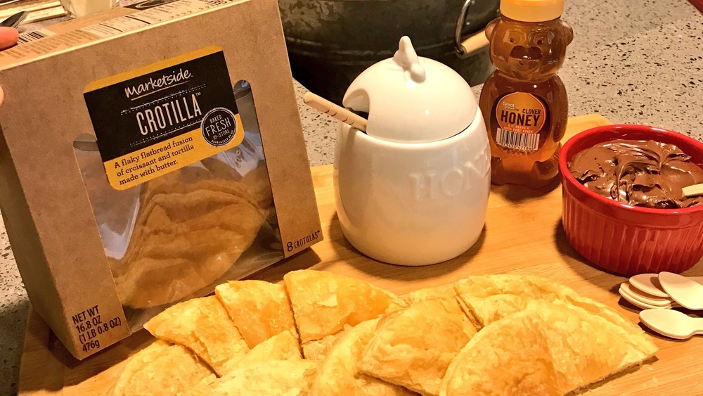 Crotillas in a box on a board with honey 