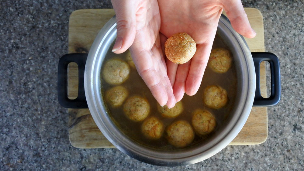 A pair of hands making mazzo ball soup