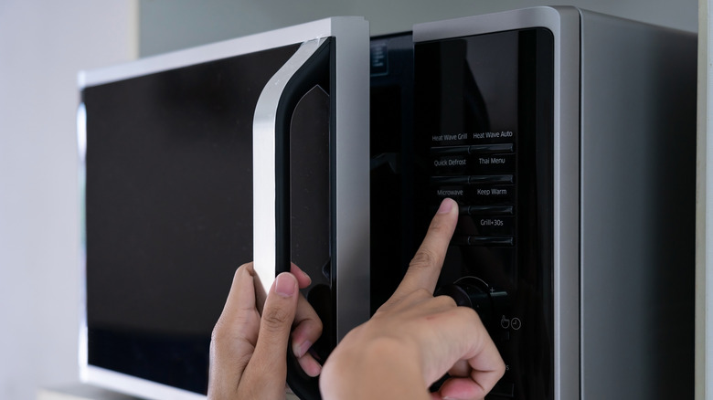 Microwave with two hands on it