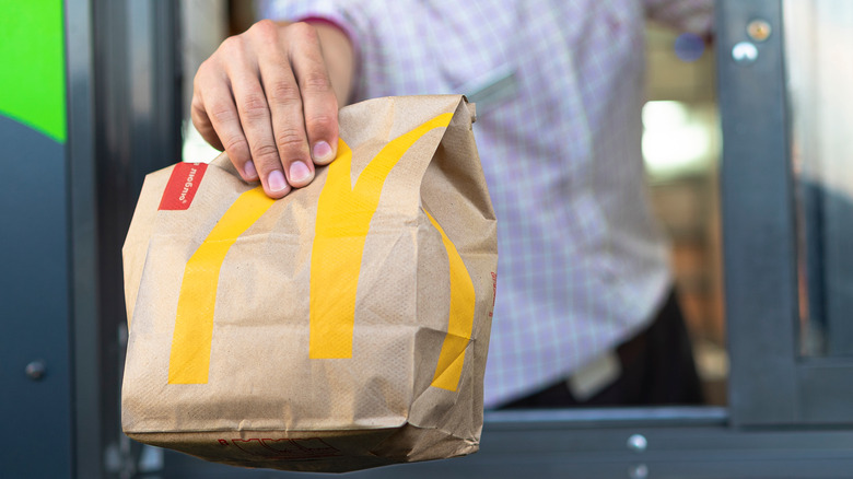 drive thru worker handing McDonald's bag