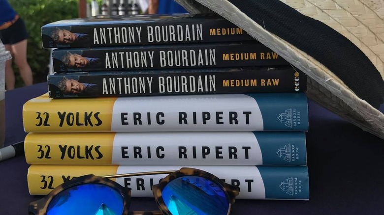 A stack of books by eric ripert and anthony bourdain