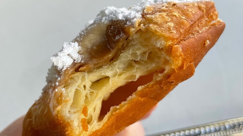 close up of a Loretta's praline beignet with a bite taken out of it