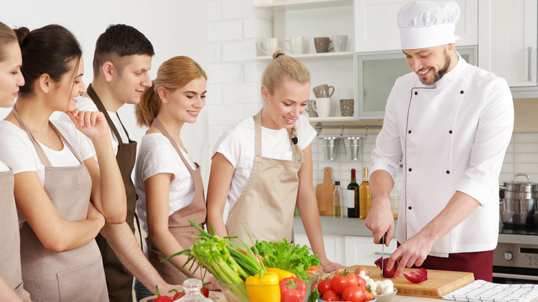 Chef teaching students at a cutting board