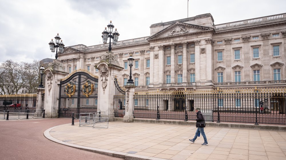 man in front of buckingham palace on empty sidewalks