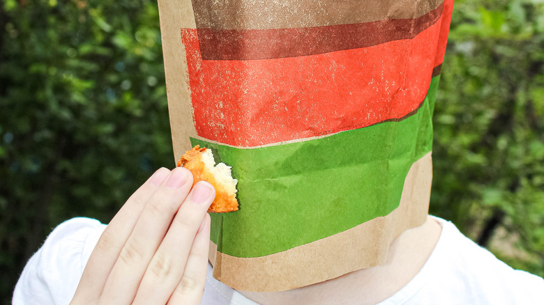 face covered in BK paper bag and holding a nugget