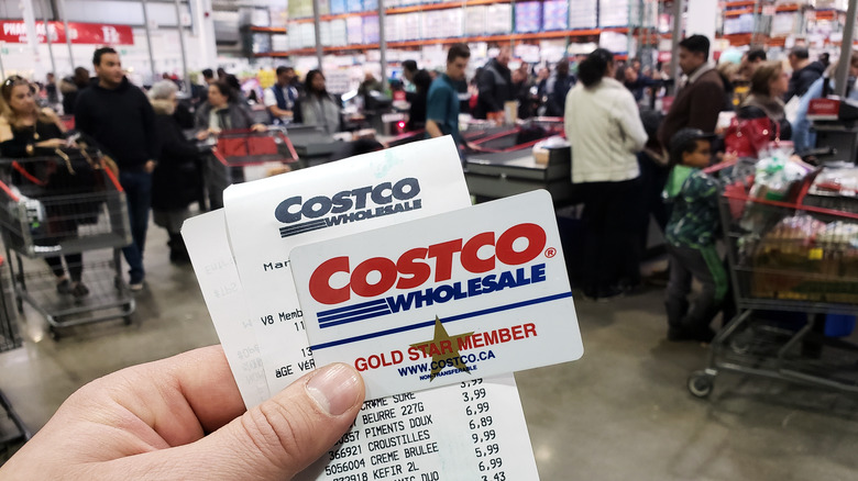 holding costco receipt and member card