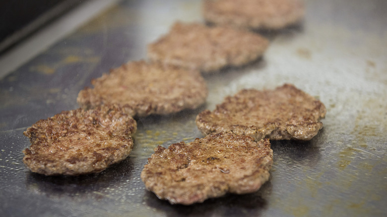 burger patties on flat top grill