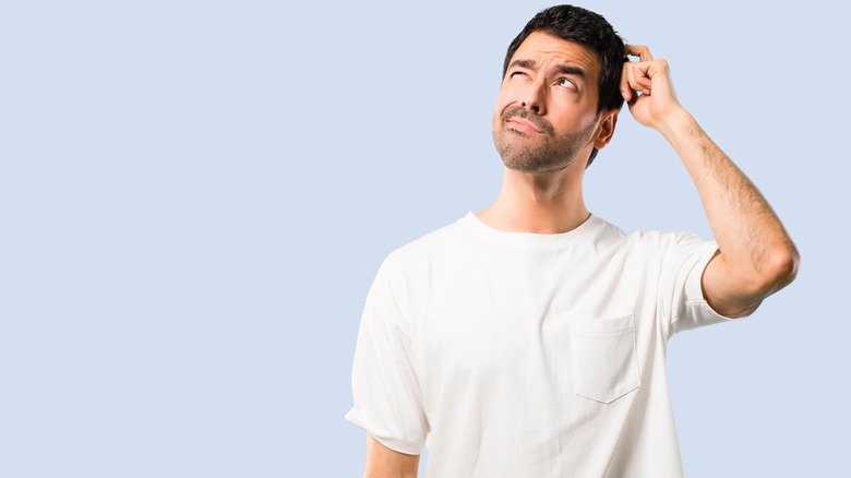 Confused-looking man in white t-shirt