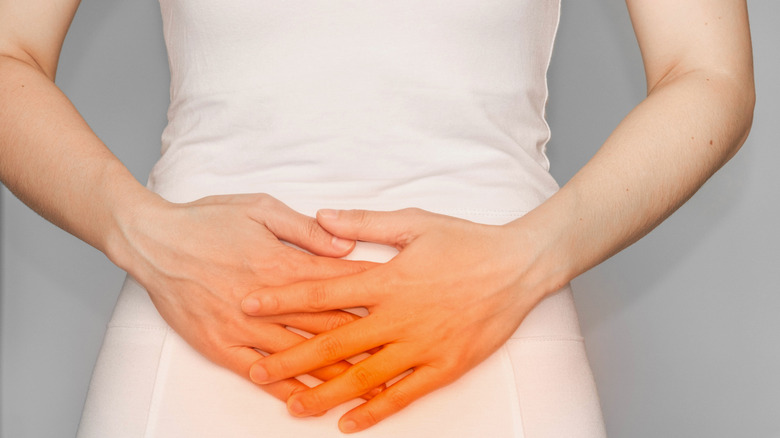 woman holding upset stomach