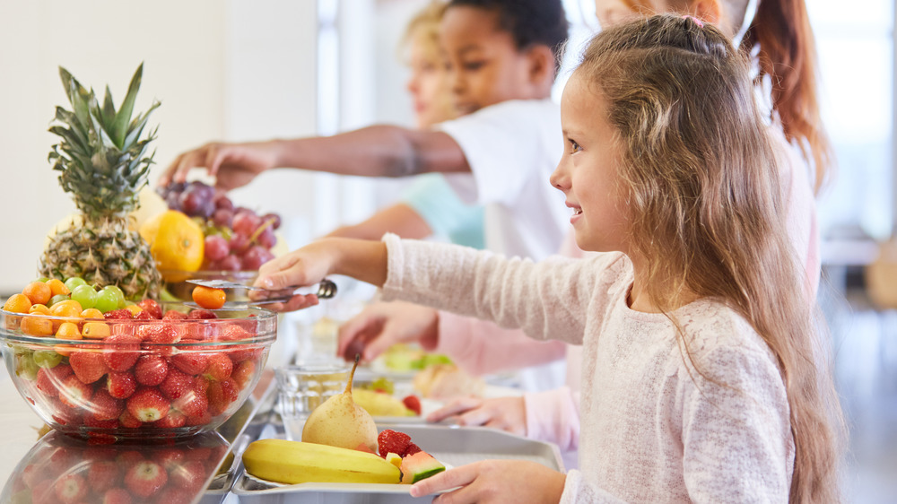 kids picking up fruit at tongs at a buffet