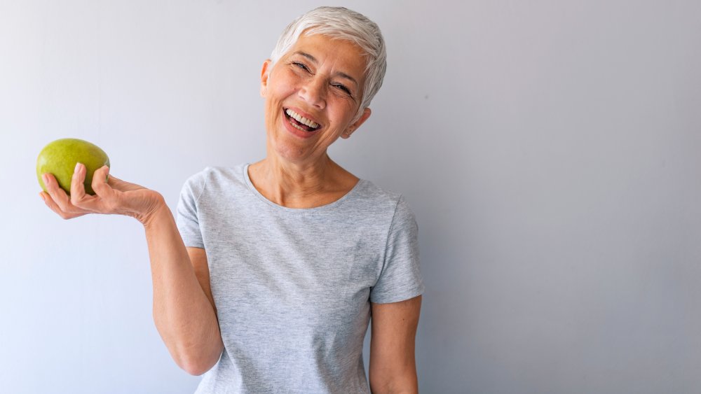 Happy woman eating fruit