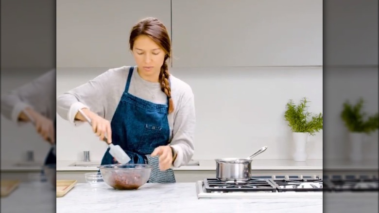 female chef at future food institute stirring a bowl at a kitchen counter