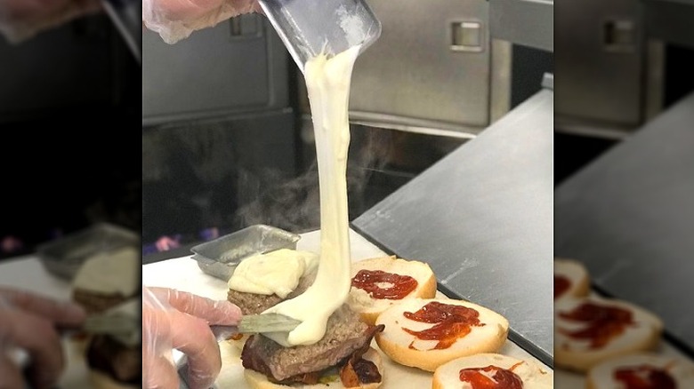 Melted cheese pouring onto burger