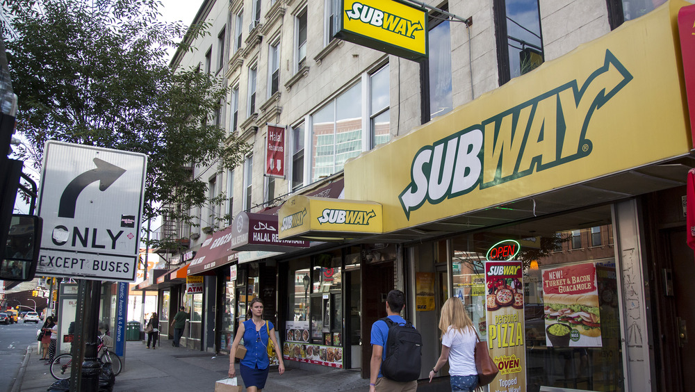 People walking outside Subway restaurant