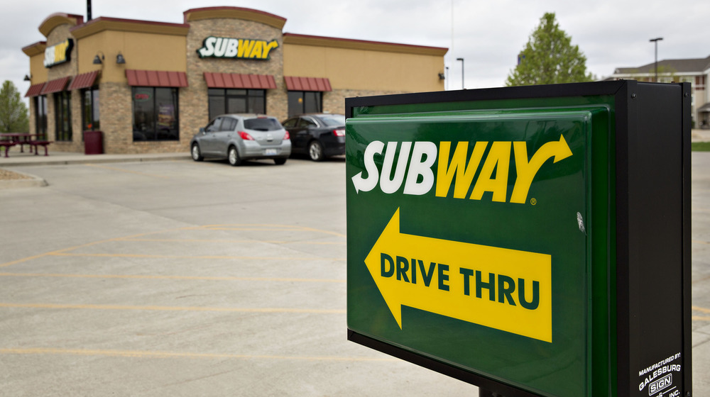 Subway sign pointing at restaurant