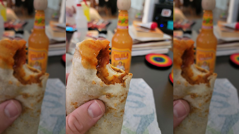 holding chili cheese burrito