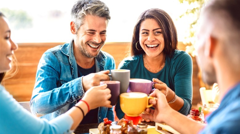 People sitting together with glasses together in air