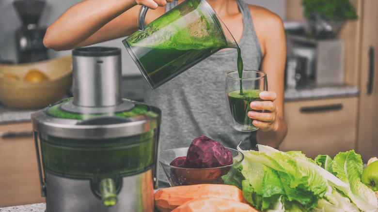 pouring green juice from machine