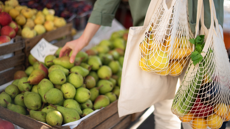 A woman buying pears