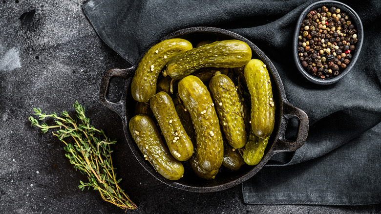 pickles in dish surrounded with herbs