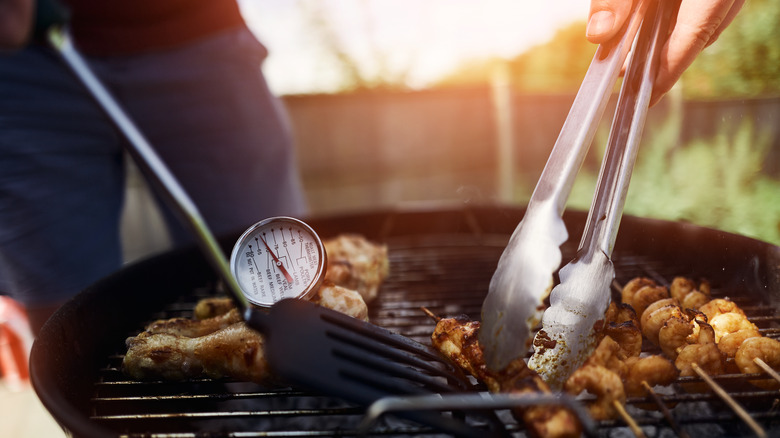 Food cooking on a grill with a food thermometer