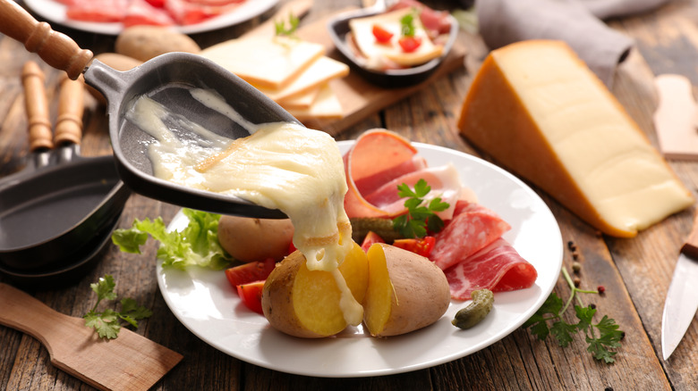 Cheese being poured over potatoes 