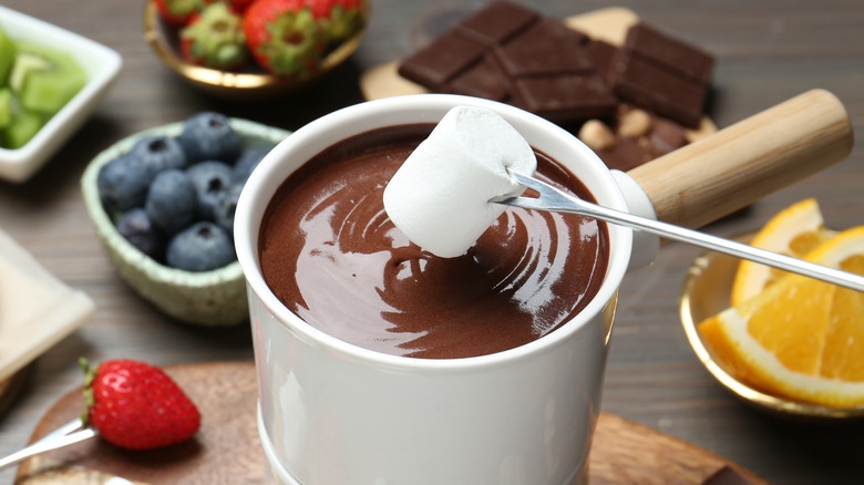 Dipping marshmallow into chocolate fondue