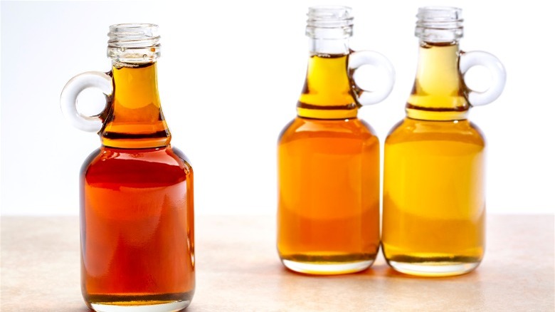 3 color grades of maple syrup in glass bottles