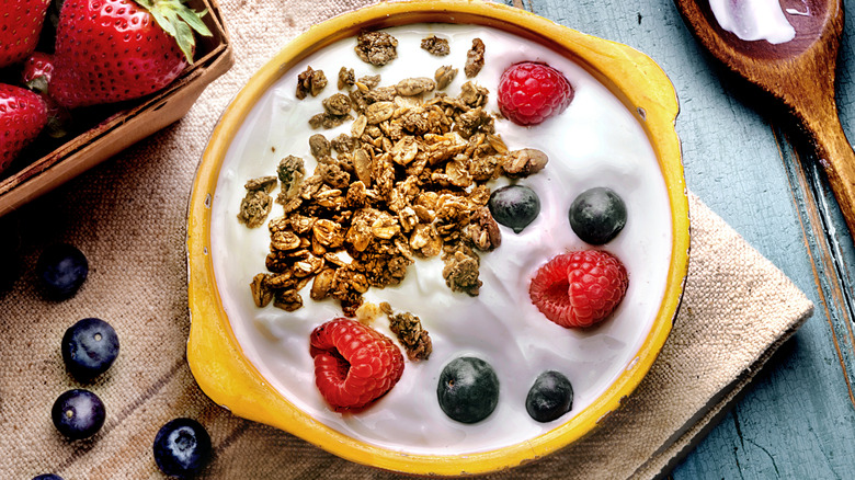 bowl of yogurt with granola, strawberries, and blueberries