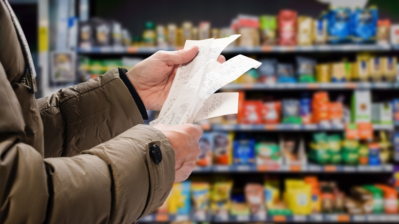 man looking at receipts in store