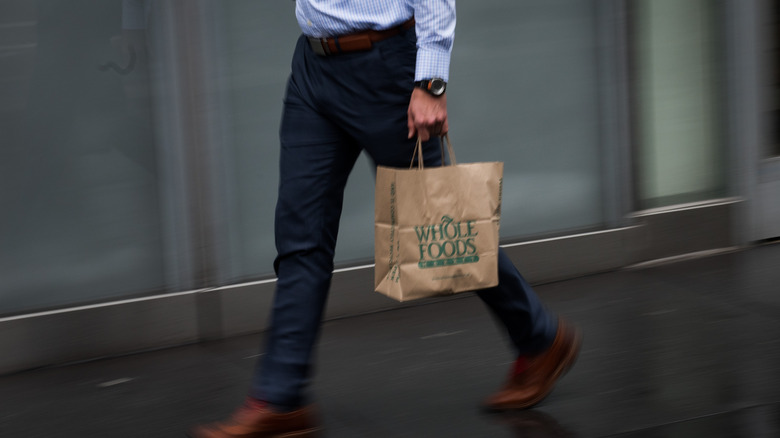 man walking with whole foods bag