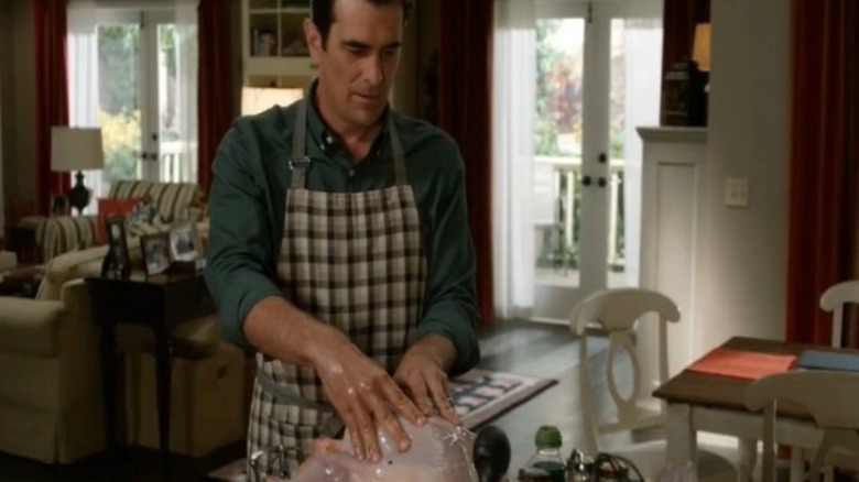 Phil Dunphy massaging turkey with oil