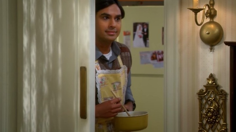 Raj stirring gravy in doorway