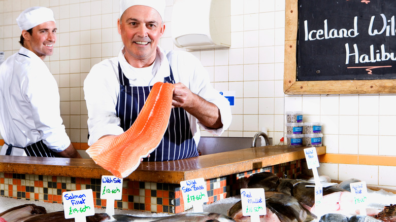 fishmonger holding fish