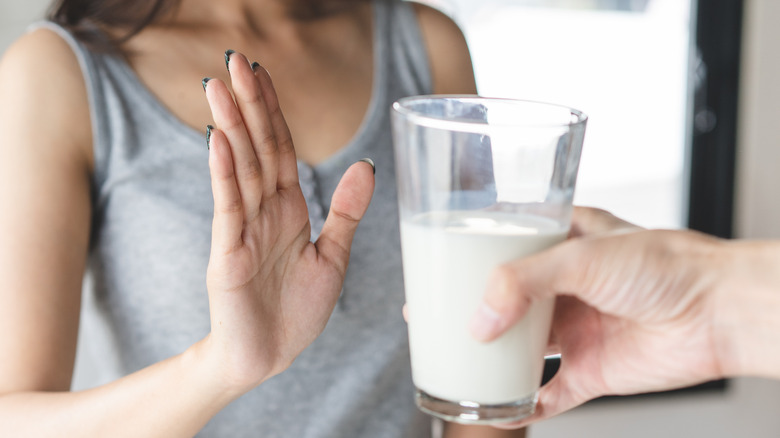 Woman refusing glass of milk