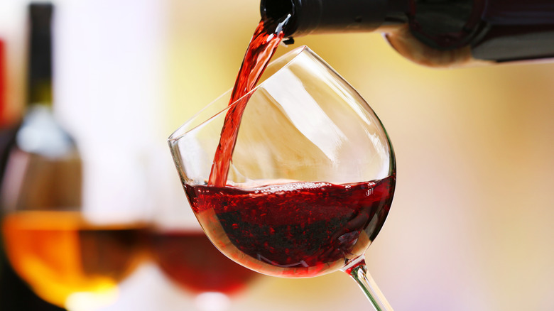 Red wine being poured into glass from bottle