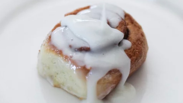 cinnamon roll with icing being poured on top