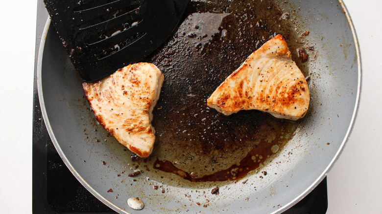 swordfish steaks cooking in a pan